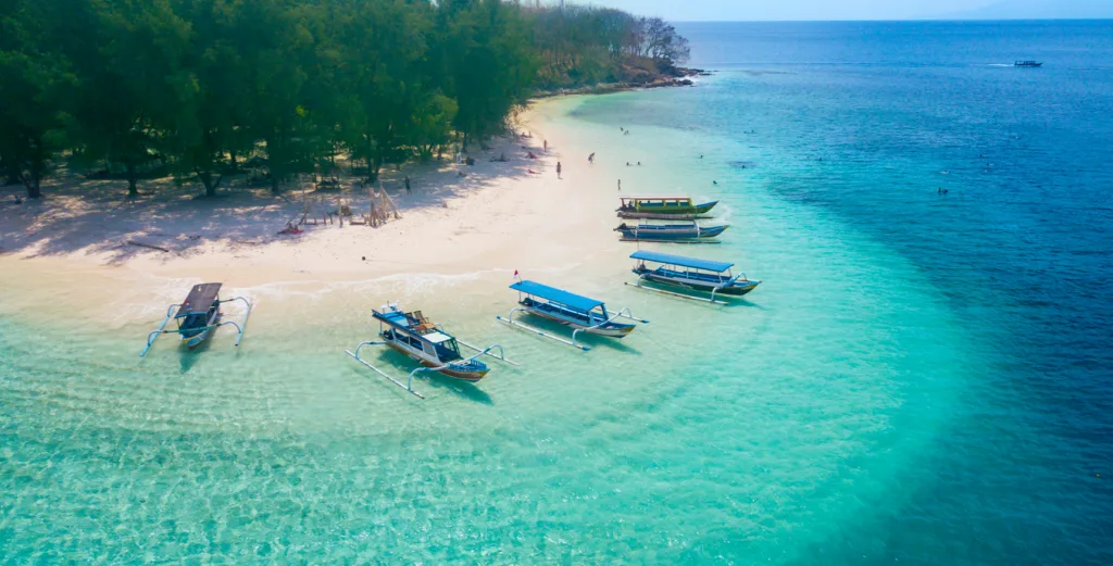 Boats anchored on Gili Rengit beach Lombok destination dupe